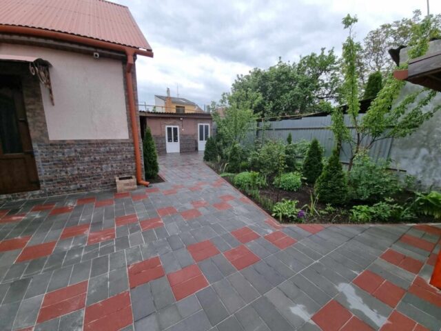 Detailní pohled na zámkovou dlažbu složenou do pravidelného vzoru na venkovní ploše.